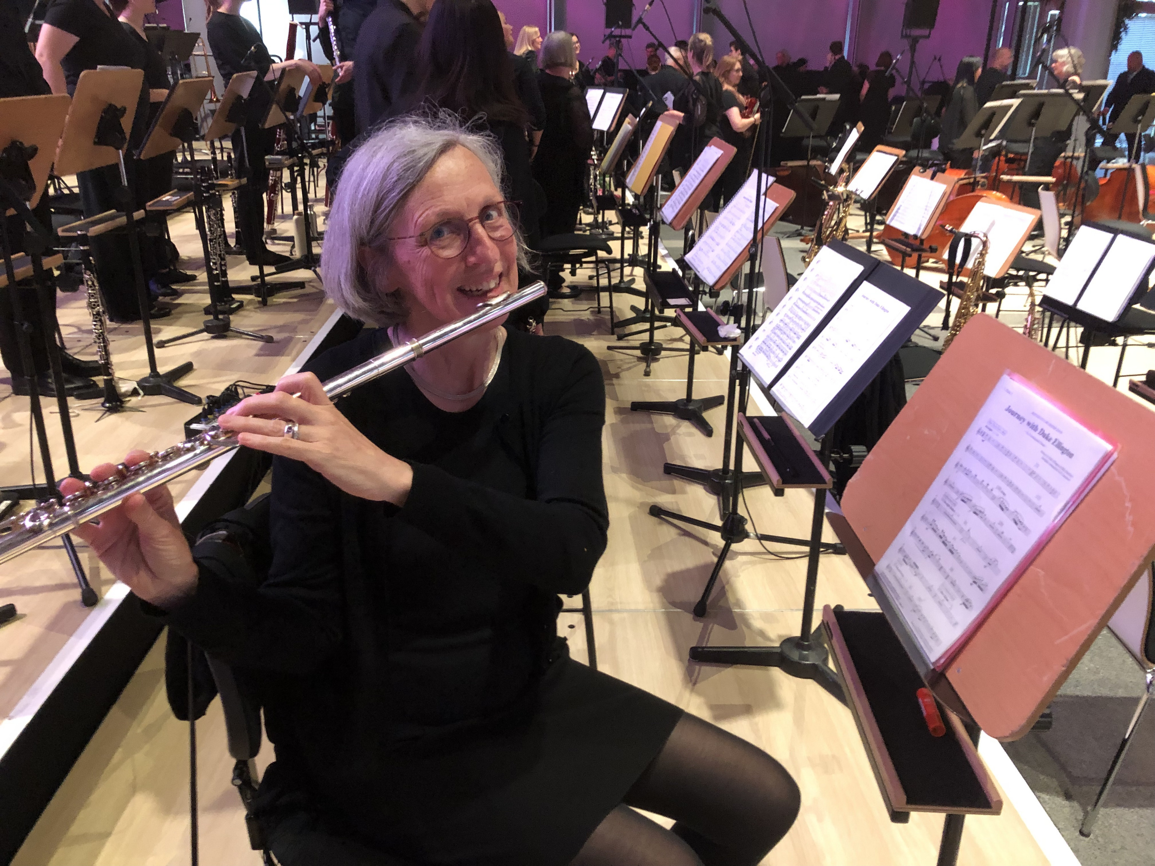 Bild der Fachleiterin, die an einem Orchester-Platz ein Querflöte spielt.