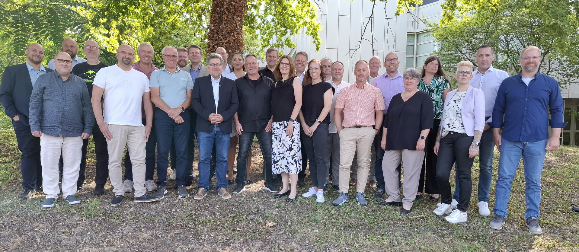 Gruppenfoto des Landeselternbeirats. Im Hintergrund Bäume und Gebäude
