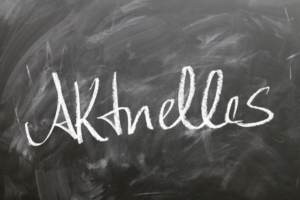 Kreidetafel mit dem groß in weißer Kreide geschriebenen Wort „Aktuelles“.
