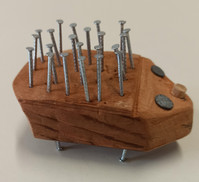 ein stilisierter Igel, gefertigt aus einem bearbeiteten Stück Holz, Korkscheiben und vielen Nägeln