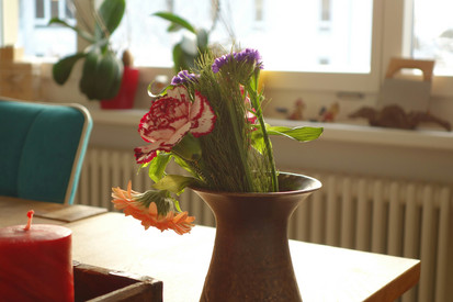 Kleiner Blumenstrauß in der Vase im Büro stehend 