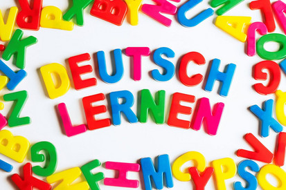 Bunte Buchstaben bilden die Wörter: Deutsch Lernen.