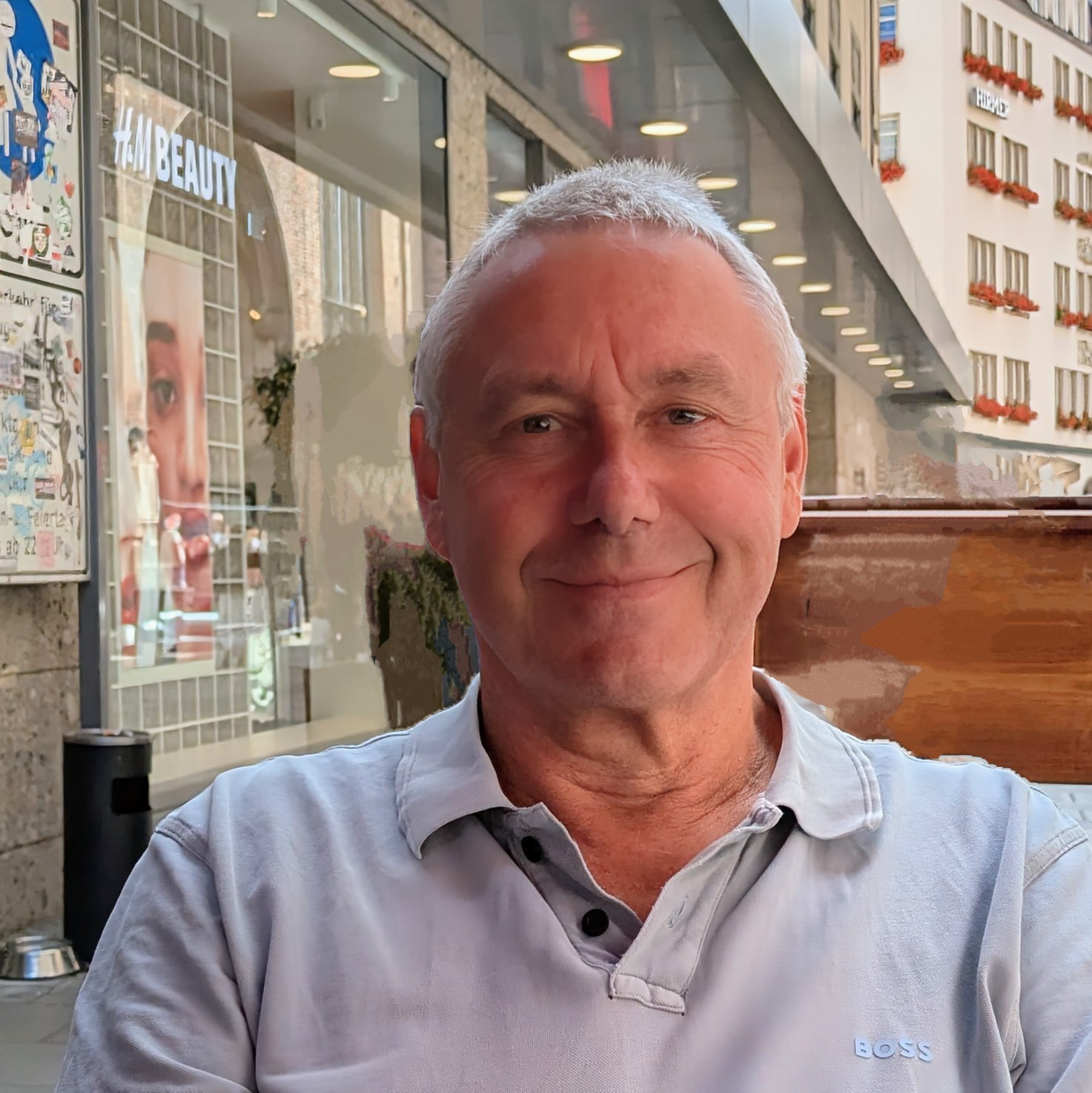 Portraitaufnahme einer lächelnden Person mit hellem Oberteil