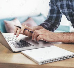 Mann, der auf Laptop schreibt