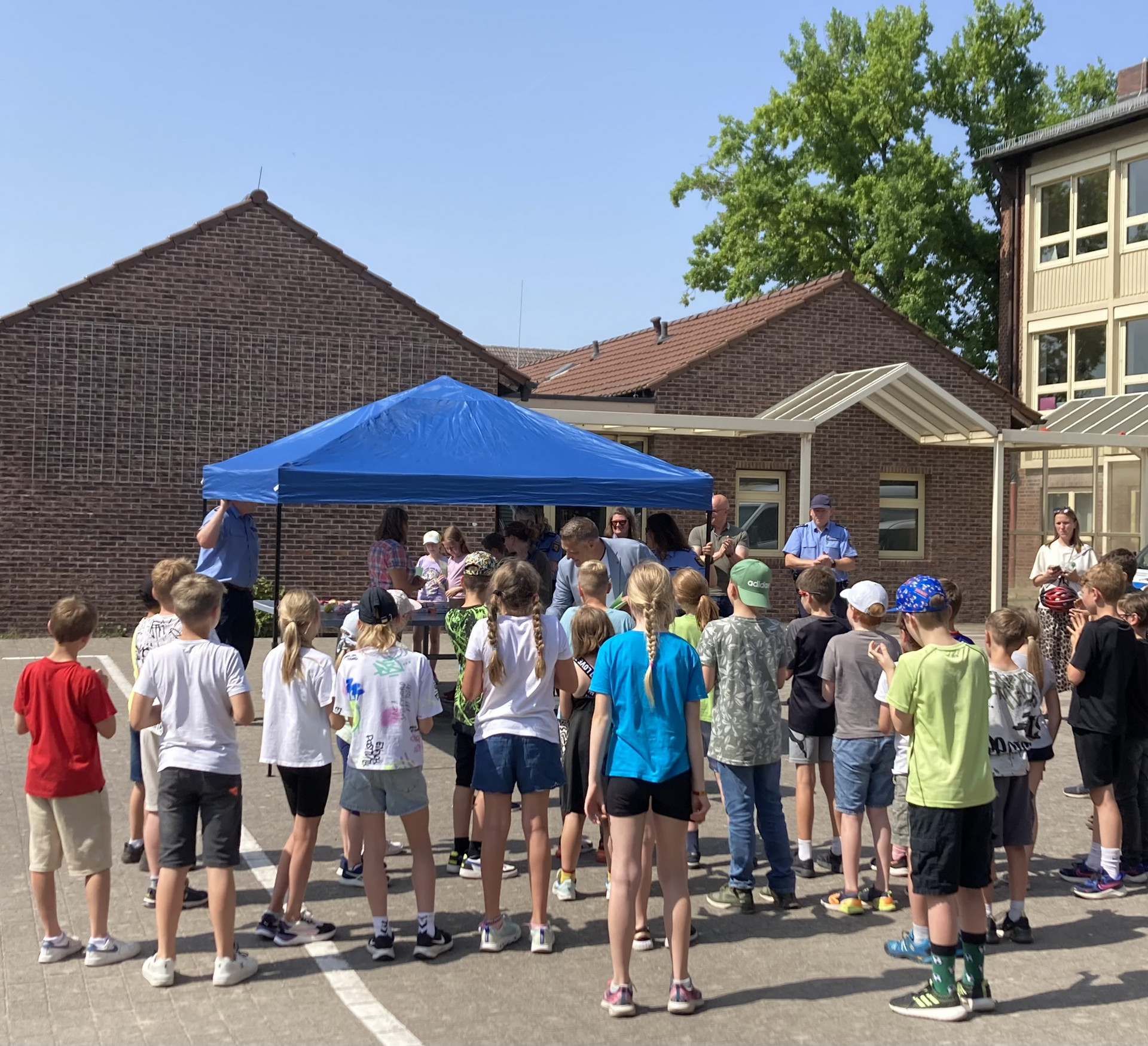 Siegerehrung der Kreisfahrradturniers Der Erste Kreisbeigeorndete Volker Knörr gratuliert den Teilnehmenden bei strahlendem Sonnenschein