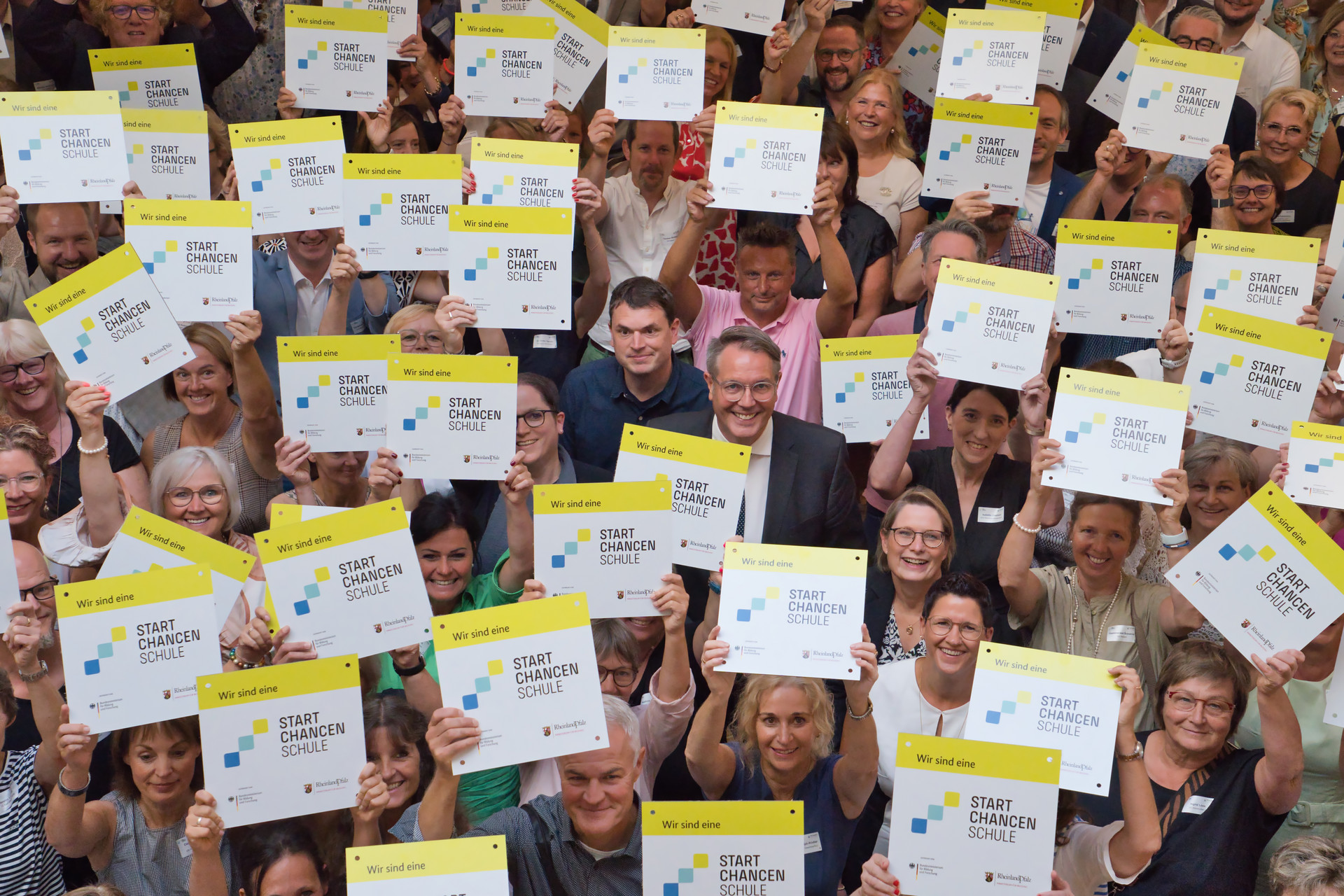 Schulleiterinnen und Schulleiter der Startchancen-Schulen mit Plakette