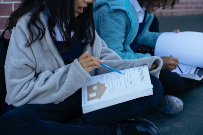 Ein Mädchen liest in einem Schulbuch.