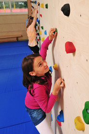 Schülerin an einer Kletterwand