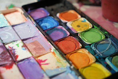 Nahaufnahme einer bunten Aquarellpalette mit kräftigen Pigmenten für Kunst und Schule.