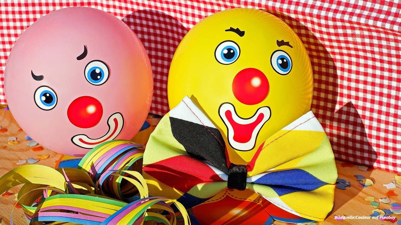 Das Bild zeigt zwei Luftballons gestaltet als Clownsgesichter in einer Faschingsdekoration.