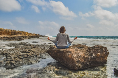 Symbolbild Lehrkräftegesundheit Frau meditiert am Meer
