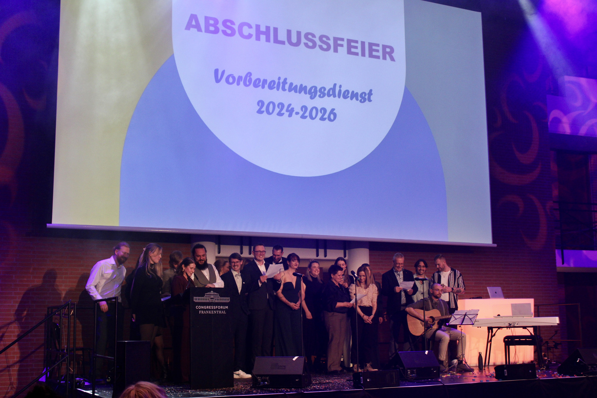 Anwärterinnen und Anwärtern zusammen mit Fachleitungen aus der Fachdidaktischen Ergänzung Sachunterricht tragen ein Lied vor.