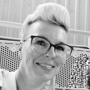 Schwarz-weiß Portrait einer Person mit hellen, kurzen Haaren und Brille