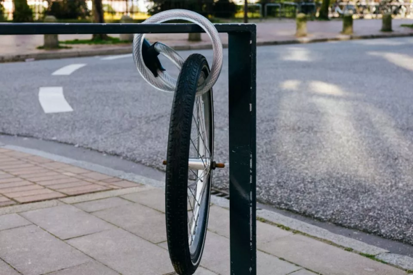Das Bild zeigt einen Fahrradreifen, der an einem Fahrradständer mit einem Fahrradschloss befestigt ist.