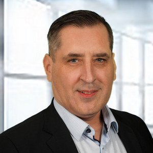 Portraitfoto einer Person mit kurzen Haaren, dunklem Jackett und hellem Hemd