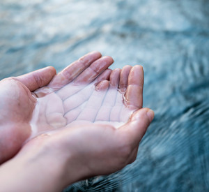 A female hand touching the river water