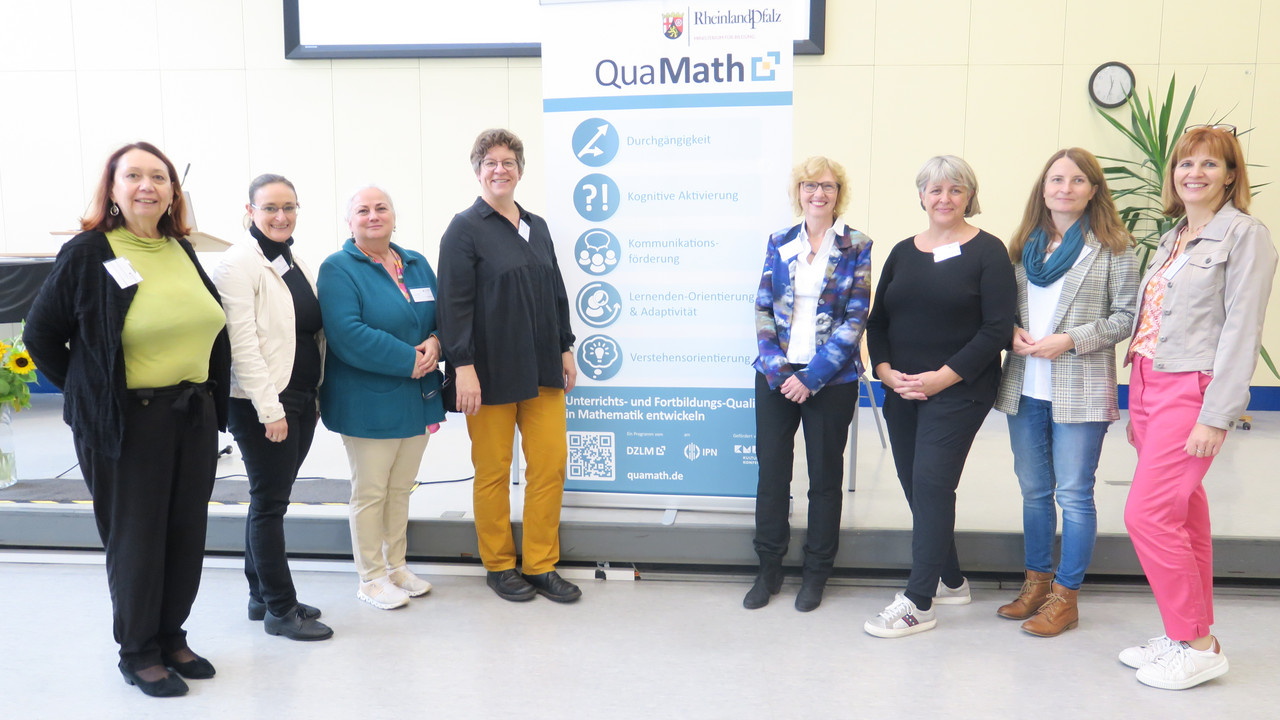 Gruppenbild 8 Frauen neben Roll-Up zum Programm QuaMath