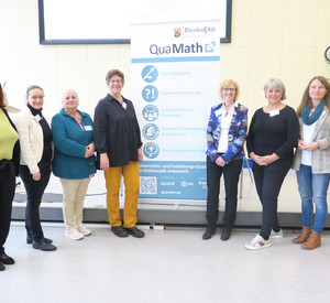 Gruppenbild 8 Frauen neben Roll-Up zum Programm QuaMath