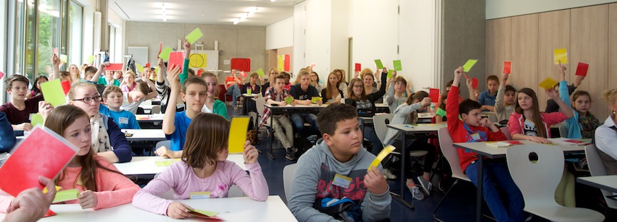 Schüler stimmen mit gelben und roten Kärtchen ab.