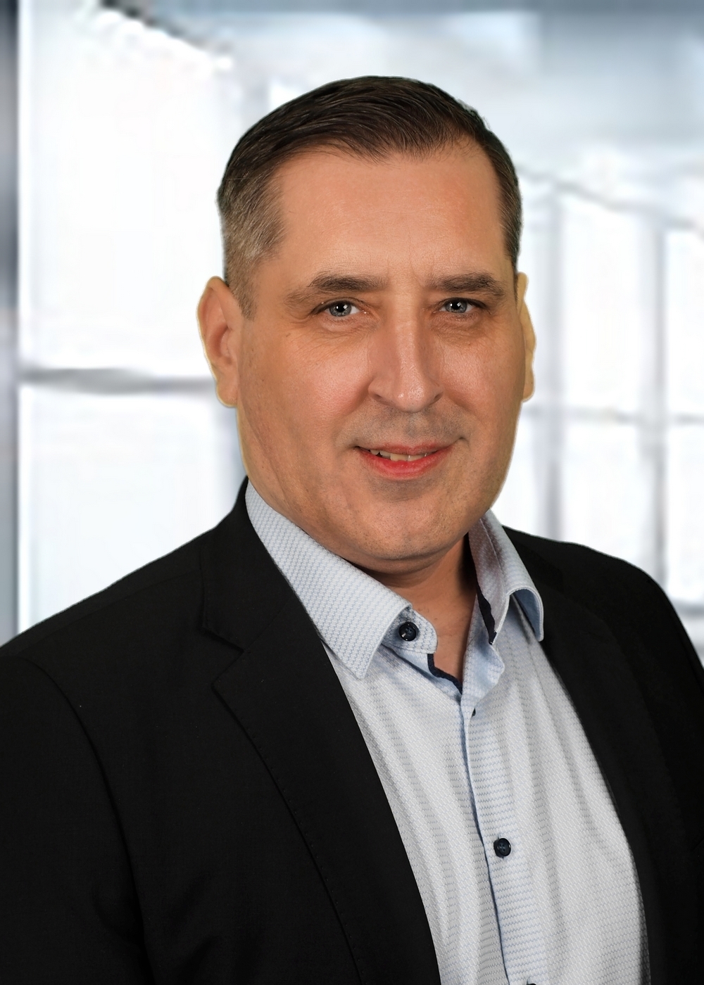 Portraitfoto einer Person mit kurzen Haaren, dunklem Jackett und hellem Hemd