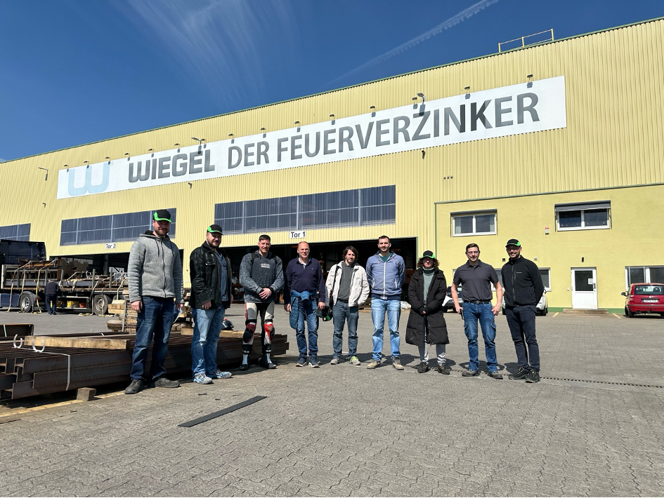 Das Bild zeigt die Betriebshalle der Firma Wiegel in Neuwied. Davor befinden sich die Teilnehmer der Fachgruppe Metall mit dem Betriebsleiter Herr Schlösser.